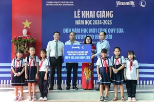 Đại diện Vinamilk & Quỹ bảo trợ trẻ em Việt Nam (bên trái) trao bảng tượng trưng phần hỗ trợ hơn 135.000 hộp sữa cho đại diện Sở Lao động thương binh & xã hội tỉnh Bến Tre nhân ngày khai giảng 5/9.