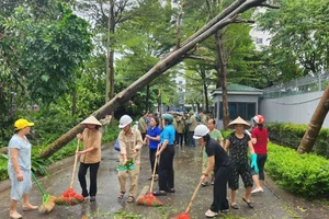 Phụ nữ quận Bắc Từ Liêm quét dọn vệ sinh môi trường sau bão số 3. 