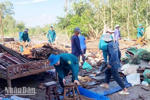 Cán bộ, chiến sĩ lực lượng vũ trang huyện Giồng Riềng khẩn trương hỗ trợ người dân khắc phục hậu quả do mưa dông, lốc xoáy gây ra.