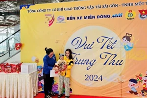 Hành khách có con nhỏ nhận quà Trung thu tại Bến xe Miền Đông mới (Thành phố Thủ Đức), Thành phố Hồ Chí Minh. (Ảnh: QUÝ HIỀN)