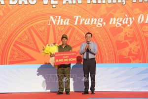 Phó Thủ tướng Chính phủ Trần Lưu Quang, Ủy viên Trung ương Đảng, Trưởng Ban Chỉ đạo 138 Chính phủ tặng quà cho đại diện Lực lượng tham gia bảo vệ an ninh trật tự ở cơ sở trên địa bàn thành phố Nha Trang. 