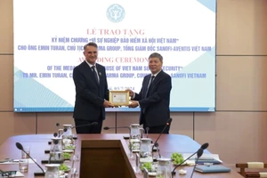 Phó Tổng Giám đốc Bảo hiểm xã hội Việt Nam Nguyễn Đức Hòa trao tặng Kỷ niệm chương “Vì sự nghiệp Bảo hiểm xã hội Việt Nam” cho ông Emin Turan. (Ảnh: VSS)