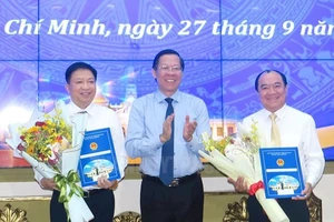 Đồng chí Phan Văn Mãi, Chủ tịch Ủy ban nhân dân Thành phố Hồ Chí Minh trao quyết định cho đồng chí Võ Thành Khả và đồng chí Lê Văn Thành (bìa phải).