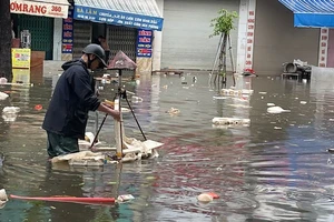 Nhân viên Công ty TNHH MTV Công trình đô thị Nam Định vớt rác trôi nổi, tiêu thoát nước úng ngập trên đường Trần Hưng Đạo, thành phố Nam Định.