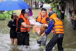 Lực lượng xung kích hỗ trợ di dời người dân khỏi vùng ngập lụt ở Nam Định.