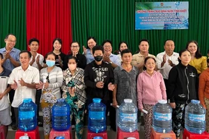 Lãnh đạo chính quyền địa phương cùng nhà tài trợ trao nước ngọt cho hội viên, nông dân gặp khó khăn tại xã Hòa Lộc, huyện Mỏ Cày Bắc, tỉnh Bến Tre.