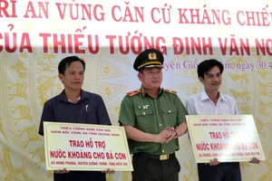Thiếu tướng Đinh Văn Nơi trao bảng tượng trưng hỗ trợ nước khoáng cho người dân vùng hạn mặn tại tỉnh Bến Tre.