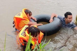 Các cán bộ, chiến sĩ Công an huyện Đầm Hà hỗ trợ đưa hộ gia đình anh Lê Văn Sơn ở thôn Đồng Tâm, xã Đại Dực vào nơi an toàn.