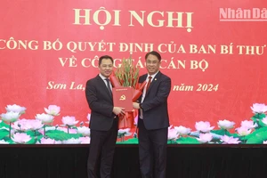 Đồng chí Phan Thăng An, Phó Trưởng Ban Tổ chức Trung ương trao Quyết định và hoa chúc mừng đồng chí Nguyễn Đình Việt.