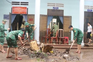 Cán bộ, chiến sĩ lực lượng vũ trang tỉnh Bình Định hộ trợ người dân, chính quyền khắc phục hậu quả mưa lũ tại phường Ghềnh Ráng.
