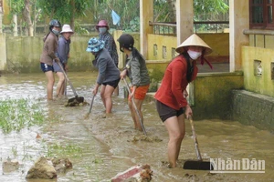 Giáo viên các trường học ở huyện Lệ Thủy dọn bùn, vệ sinh trường lớp để học sinh đi học trở lại.