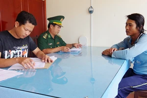 Đồn Biên phòng Trung Bình làm thủ tục bàn giao đối tượng Hữu Nghiêm (phải) cho Công an thị xã Giá Rai, tỉnh Bạc Liêu. 