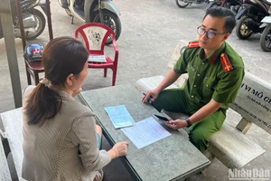 Đại úy Đặng Hồng Nhất hỗ trợ người dân địa phương làm thủ tục hành chính.