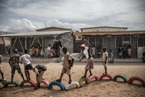 Học sinh vui chơi bên ngoài lớp học mới làm bằng gạch nhựa ở Abidjan, Bờ Biển Ngà.