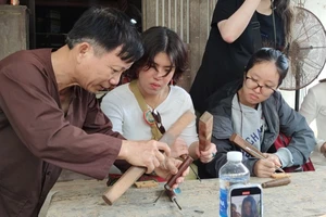 Nghệ nhân Ưu tú Huỳnh Sướng hướng dẫn các bạn sinh viên Hồng Công (Trung Quốc) trải nghiệm nghề mộc.