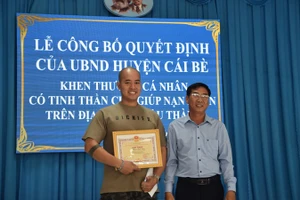 Lãnh đạo huyện Cái Bè trao giấy khen cho anh Phan Quốc Huy.