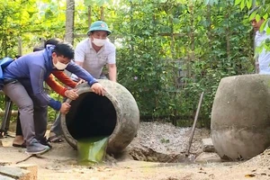Các lực lượng chức năng trợ giúp hộ dân ở phường Hải Thanh đổ kiệt nước đọng trong các chum.