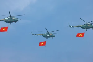 Phần trình diễn của trực thăng mang cờ Đảng, cờ Tổ quốc tại Lễ kỷ niệm 70 năm Chiến thắng Điện Biên Phủ. (Ảnh: TTXVN)
