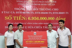 Ông Lê Minh Thép (đứng thứ 2 từ bên phải sang) chủ tàu cá BTh-96789-TS nhận thông báo bồi thường tại trụ sở công ty Bảo Minh Bình Thuận.
