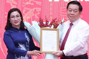 Trưởng Ban Tuyên giáo Trung ương Nguyễn Trọng Nghĩa trao Quyết định cho đồng chí Đinh Thị Mai. (Ảnh: TTXVN)