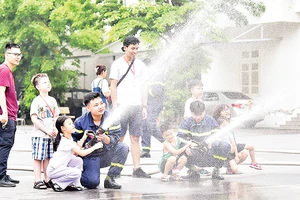 Các em học sinh tham gia thực hành cùng cán bộ, chiến sĩ Trường đại học Phòng cháy chữa cháy. (Ảnh MỸ HÀ) 