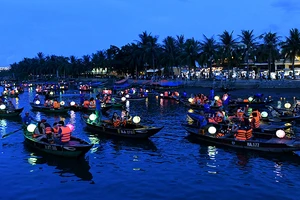 Du khách đi thuyền trên sông Hoài tham quan phố cổ Hội An vào ban đêm. (Ảnh ÐĂNG KHOA) 