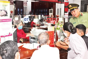 Công an thành phố Biên Hòa tuyên truyền về phương thức, thủ đoạn của tội phạm cho khách hàng đến giao dịch tại Agribank chi nhánh tỉnh Ðồng Nai. (Ảnh tư liệu) 