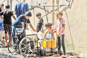 Người dân lấy nước ở thành phố Khan Younis thuộc Dải Gaza. (Ảnh TÂN HOA XÃ) 