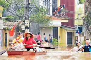 Người dân xã Yên Mỹ, huyện Thanh Trì, Hà Nội được hỗ trợ di chuyển đến nơi an toàn khi nước dâng cao. (Ảnh THẾ ÐẠI) 