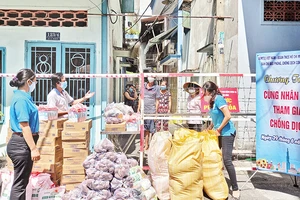 Cán bộ Mặt trận và các tổ chức thành viên trao thực phẩm hỗ trợ người dân trong giai đoạn đại dịch Covid-19 diễn biến căng thẳng tại Thành phố Hồ Chí Minh. 