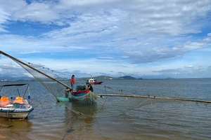 Cán bộ Đồn Biên phòng Nhơn Lý dẫn giải tàu cá ông Đinh Văn Ơi vào bờ.