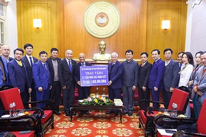 Đồng chí Đỗ Văn Chiến (thứ 9 từ phải sang) tiếp nhận kinh phí tượng trưng từ Chủ tịch Hiệp hội Doanh nhân Việt Nam ở nước ngoài Peter Hồng. 