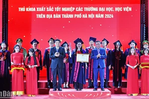 Chủ nhiệm Ủy ban Văn hóa, Giáo dục của Quốc hội Nguyễn Đắc Vinh và Phó Bí thư Thành ủy Hà Nội Nguyễn Văn Phong trao Bằng khen, kỷ niệm chương tặng các thủ khoa xuất sắc, tiêu biểu tại buổi lễ.