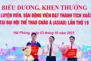 Lãnh đạo Ủy ban nhân dân thành phố Hải Phòng trao Bằng khen và tiền thưởng tặng vận động viên Phạm Quang Huy (trái) và huấn luyện viên Phạm Cao Sơn (phải).