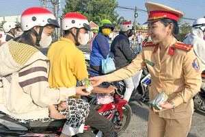 Lực lượng cảnh sát giao thông Công an tỉnh Vĩnh Long tặng nước suối và sữa cho người đi đường