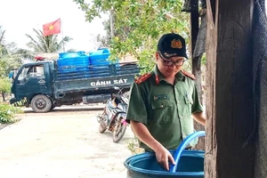 Công an huyện Ea Súp sử dụng các phương tiện chở nước sạch hỗ trợ người dân thôn 2, xã biên giới Ia Rvê sinh hoạt.