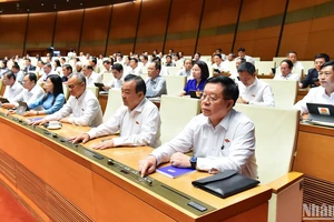 Đại biểu Quốc hội biểu quyết thông qua Nghị quyết của Quốc hội về việc sửa đổi, bổ sung một số điều của Hiến pháp năm 2013. (Ảnh: BÙI GIANG)