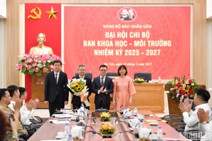 Đồng chí Lê Quốc Minh, Tổng Biên tập, Bí thư Đảng ủy Báo Nhân Dân tặng hoa chúc mừng Chi ủy khóa mới của Chi bộ Ban Khoa học - Môi trường. (Ảnh: THẾ ĐẠI)