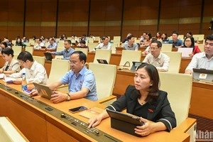 Các đại biểu Quốc hội bấm nút thông qua việc điều chỉnh Chương trình Kỳ họp thứ 9, Quốc hội khóa XV. (Ảnh: BÙI GIANG)
