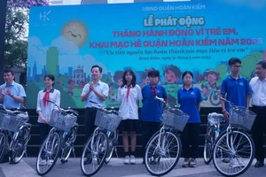 Đại diện lãnh đạo quận Hoàn Kiếm tặng xe đạp cho các em học sinh.