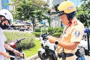 Cảnh sát giao thông Thành phố Hồ Chí Minh kiểm tra, xử lý hành chính một trường hợp học sinh tham gia giao thông bằng xe máy. 