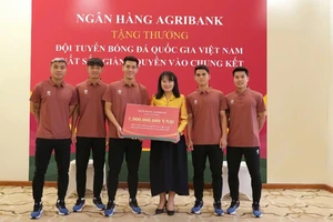 Bà Phùng Thị Bình - Phó Tổng Giám đốc Agribank trao thưởng 1 tỷ đồng cho đại diện Đội tuyển bóng đá quốc gia Việt Nam.