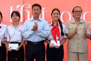 Ban Tổ chức Lễ ra mắt sách "Khát vọng hòa bình" trao phần thưởng cho các em học sinh giỏi của xã Bình Dương, huyện Thăng Bình, tỉnh Quảng Nam.