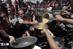 Người dân Palestine nhận thức ăn cứu trợ tại trại tị nạn Jabalia, miền bắc Dải Gaza ngày 19/5. (Ảnh: THX/TTXVN)