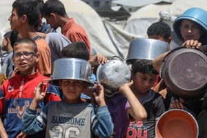 Người dân Gaza xếp hàng chờ được phân phát thực phẩm. (Ảnh: TÂN HOA XÃ)