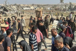 Người Palestine nhận viện trợ nhân đạo từ một trung tâm phân phối ở phía nam Dải Gaza. (Ảnh: TÂN HOA XÃ)