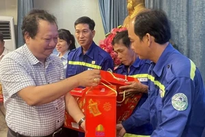 Ông Lưu Quốc Thắng, Phó Trưởng Cơ quan thường trực Báo Nhân Dân tại Thành phố Hồ Chí Minh trao quà cho công nhân.