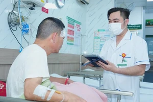 Nhân viên y tế Bệnh viện Bạch Mai sử dụng bệnh án điện tử trong quá trình thăm khám cho bệnh nhân.
