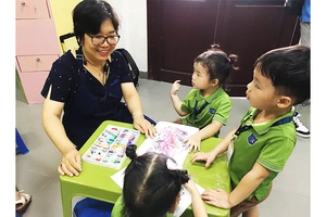 Họa sĩ Vương Lê Mỹ Học hướng dẫn cho trẻ em của lớp Penguin - Trường mầm non Creative Kindercare.