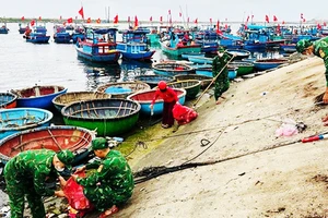 Người dân và lính biên phòng thu gom rác dọc bờ biển.